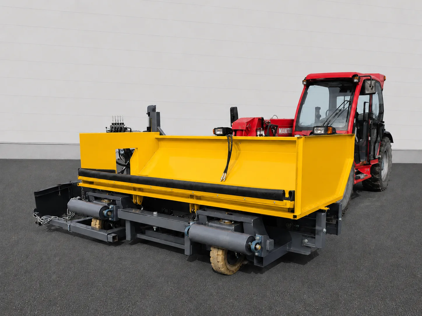 Road widening paver close-up showing the yellow hopper with a red tractor cab behind