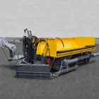 Road widening paver three-quarter view with yellow hopper, operator seat and hydraulic hoses