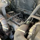 Voegele Super 1800-1 asphalt paver engine compartment with exhaust pipe and fuel lines