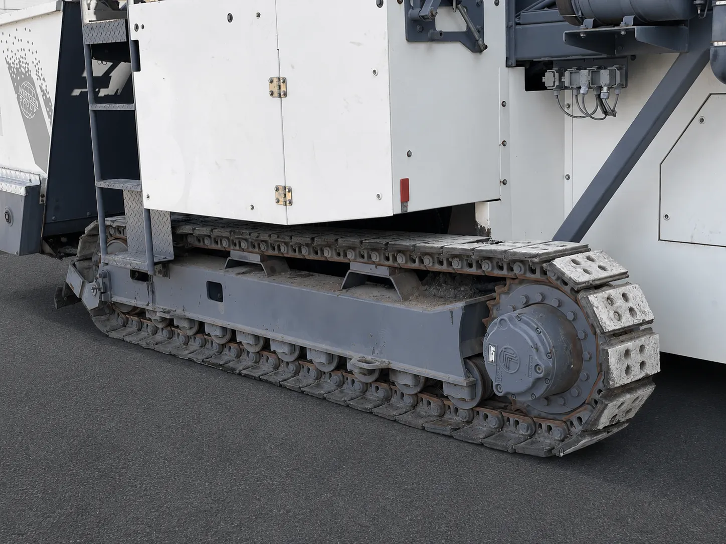 Voegele MT 1000-1 asphalt feeder close-up of a crawler track with rubber pads and access ladder
