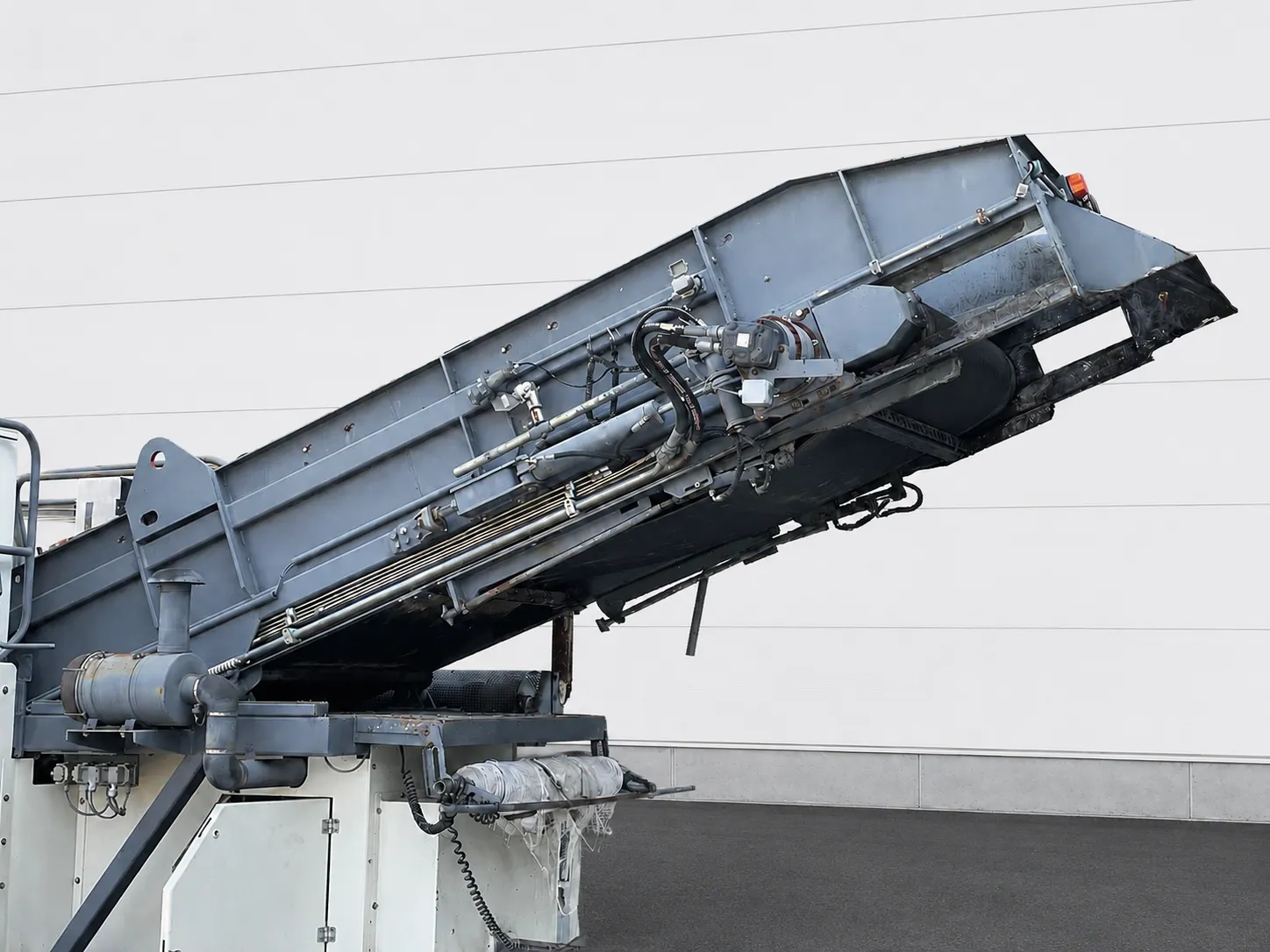 Voegele MT 1000-1 asphalt feeder close-up of the raised conveyor and hydraulic lines