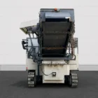 Voegele MT 1000-1 asphalt feeder end view showing the raised conveyor and crawler tracks