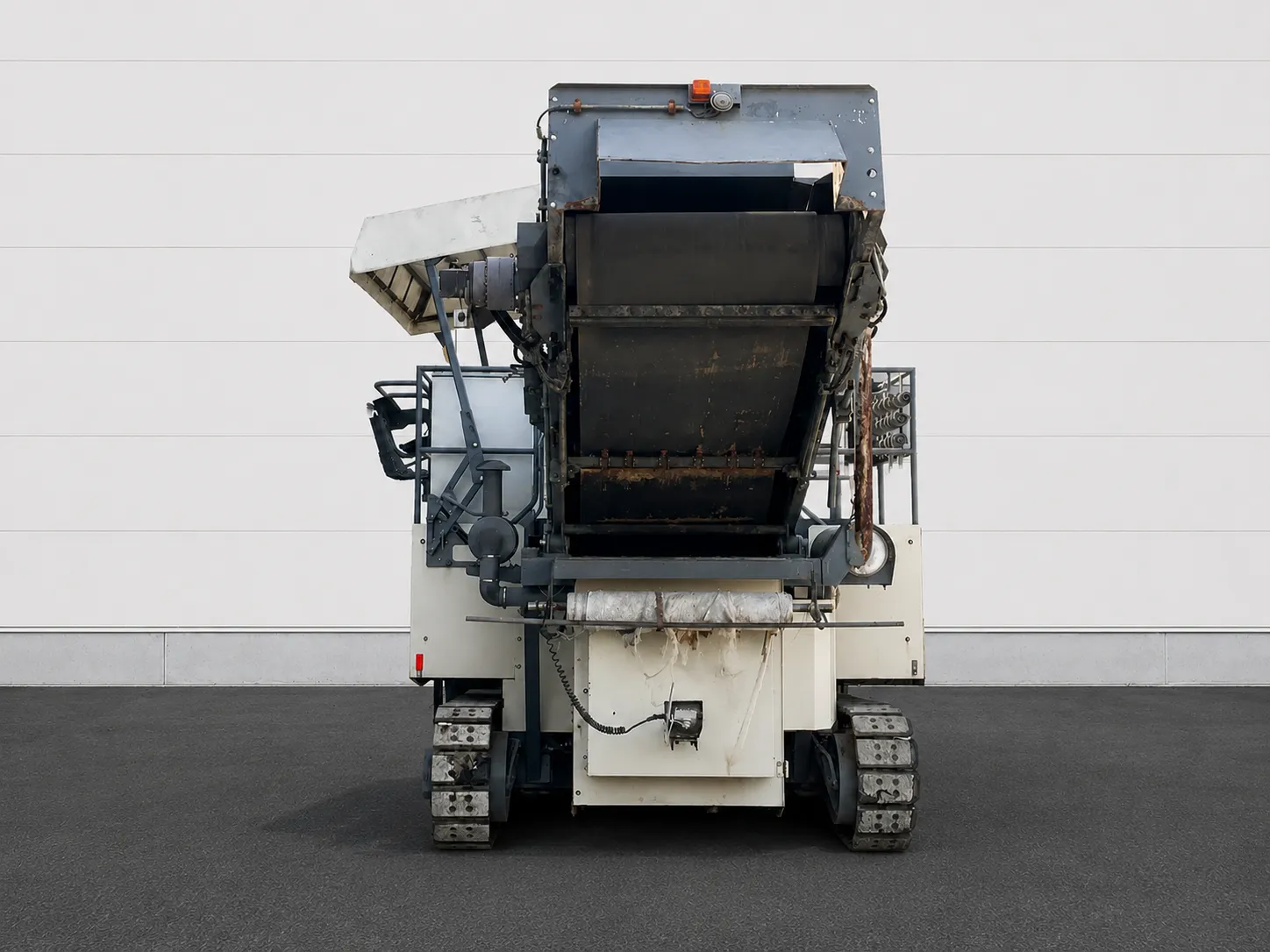 Voegele MT 1000-1 asphalt feeder end view showing the raised conveyor and crawler tracks