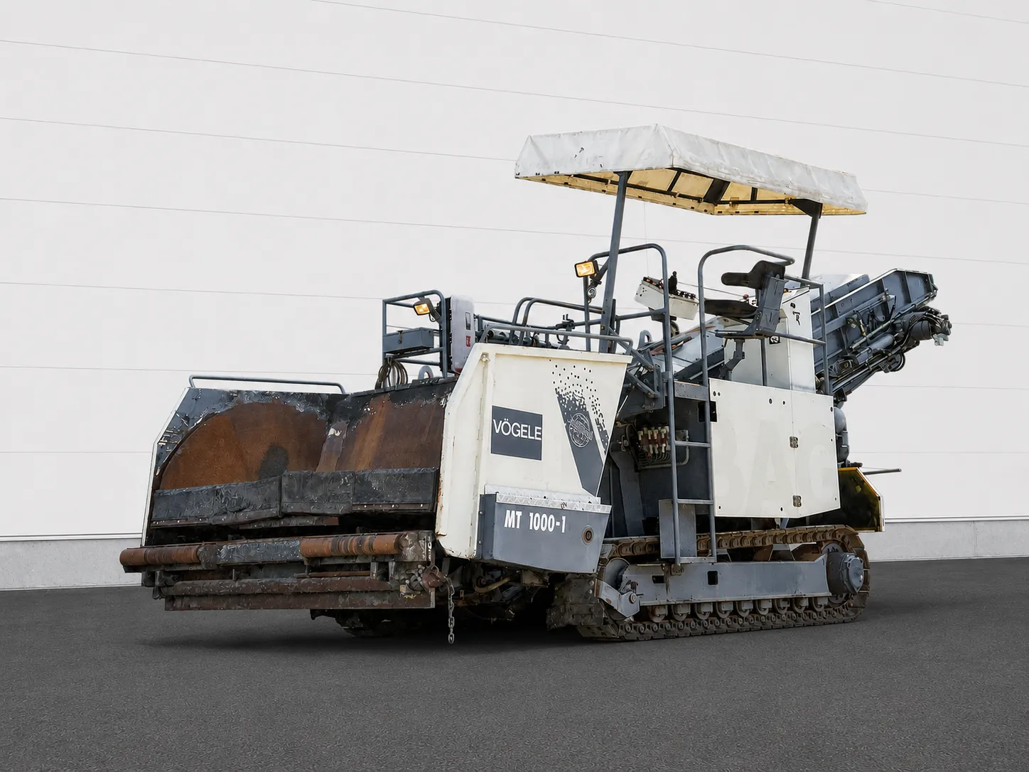 Voegele MT 1000-1 asphalt feeder three-quarter view with receiving hopper, operator canopy and raised conveyor